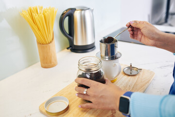 Hands of woman making Vietnamese style coffee at home in the morning