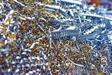 光る大量のカラフルな金属スクラップ