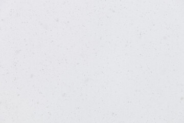 View of real snow with selective focus. Snow falling from the sky on a blizzard background. Heavy snowfall and light background.
