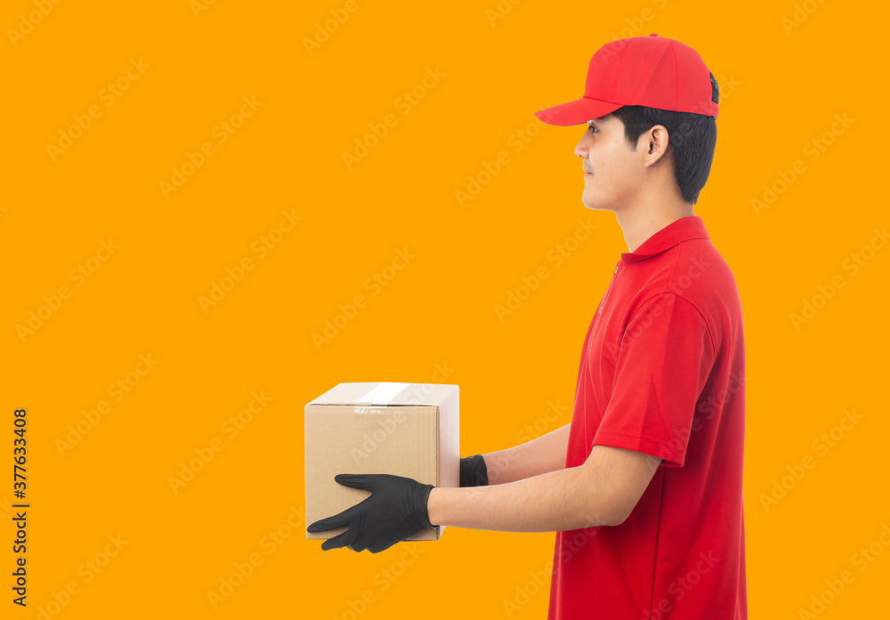 Wall mural young delivery man holding paper cardboard box mockup template.