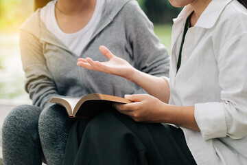 Two women studying and  talking about the bible .