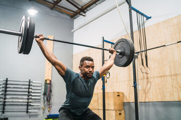 Crossfit athlete doing exercise with a barbell.