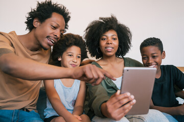 Family taking selfie together with tablet at home.