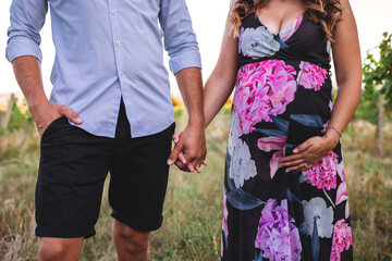 Young couple expecting baby. Parents holding hands together. Pregnant woman with her husband