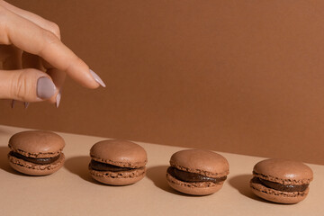 Chocolate macaroons on a beige background.