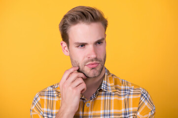 Obraz premium Facial care. Handsome man with unshaven face yellow background. Young skin. Beard grooming. Skin cosmetics. Cosmetic products. Skincare routine. Scrub and scrubbing. Shaving line. Aftershave cream