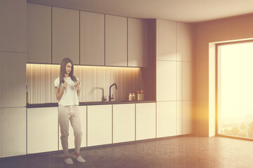 Woman in white kitchen with cabinets