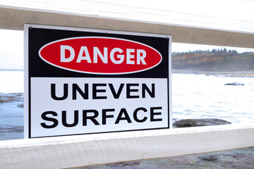 Danger: Uneven surface sign at the beach.