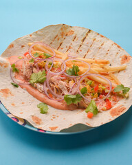 Wrap sandwich. Lavash bread with filling - grilled sausage, french fries and vegetables. Fast food, junk food concept.