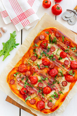 Pizza with bacon, sausage, mozzarella, tomatoes and basil. Italian cuisine. Recipe.