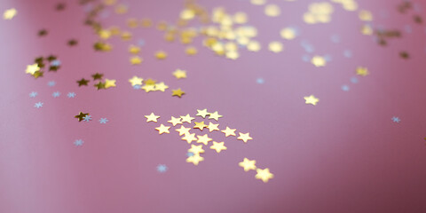 Stars and snowflakes on a pink background, from above