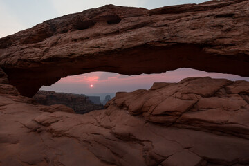 Colorful dawn frames by Mesa Arch in Canyonland National park, Utah