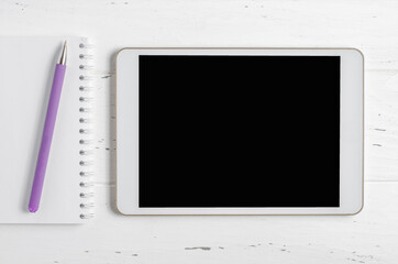 A tablet with an empty screen on a white wooden background. Concept online learning. Copy space