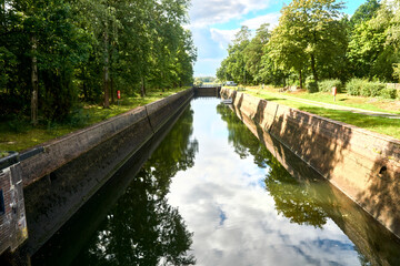 Half filled lock chamber in the river Aller near Celle, Germany, with trees on the sunny edge of the lock basin