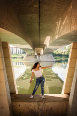 Young Teenage Girl Taking A Picture Under A Bridge.