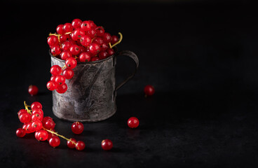 red ripe bunches of currants in an iron mug