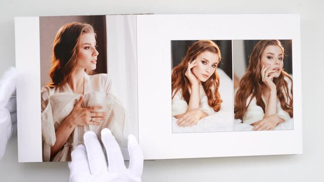 hands in white gloves flipping through a photo book with wedding photos.