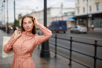 Fototapeta premium Beautiful young woman wearing dress and posing on the city street