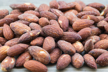 Closeup salted and roasted almonds on wooden. peeled almonds