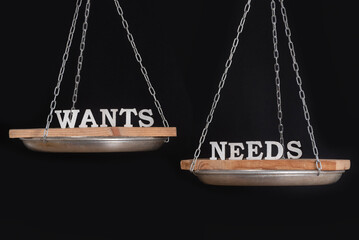 Balance what you want and what you need. Scales on black background, close up