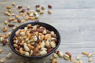 Mixed nuts in a bowl on wooden table,with copy space.