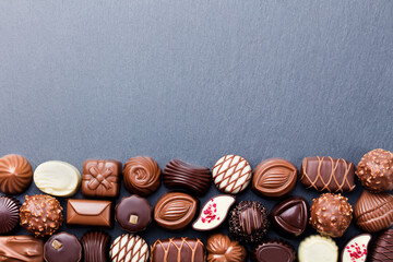 Assortment of fine chocolate candies, white, dark, and milk chocolate Sweets background. Copy...