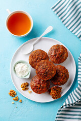 Healthy vegan carrot muffins with ricotta cheese and cup of tea. Blue stone background. Top view.