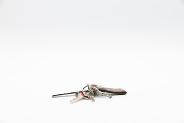Bunch of keys with old and worn keychain isolated on white background.