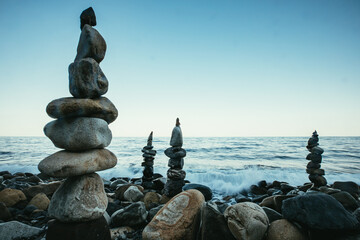 Zen style balanced stones on beach. Rock sculpture stone stacking. A stone pyramid on sea shore.