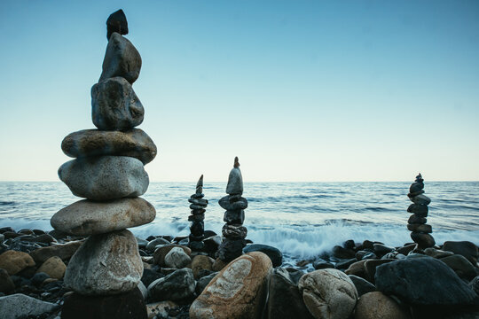 Zen style balanced stones on beach. Rock sculpture stone stacking. A stone pyramid on sea shore.