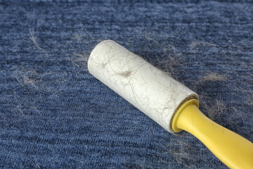 Lint roller on blue fabric covered with hair