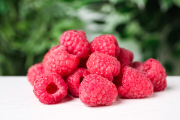 Delicious fresh ripe raspberries on white wooden table, closeup