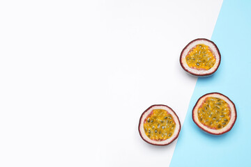Halves of fresh ripe passion fruits (maracuyas) on color background, flat lay. Space for text