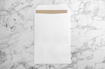 White paper envelope on marble background, top view
