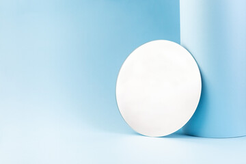 Round mirror on a blue paper, trendy minimalistic background, horizontal, copy space