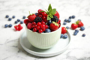 Mix of ripe berries on white marble table