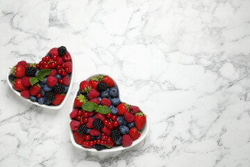 Mix of ripe berries on white marble table, flat lay. Space for text