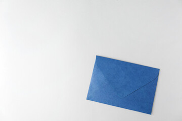 Blue paper envelope on light background, top view. Space for text