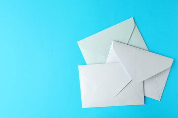 White paper envelopes on light blue background, flat lay. Space for text