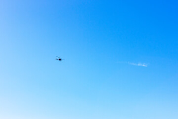 Fototapeta na wymiar A helicopter flying in the clear blue sky