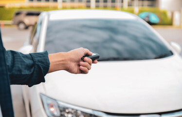 Car remote control by smart key, Hand holding smart key to lock doors of white car