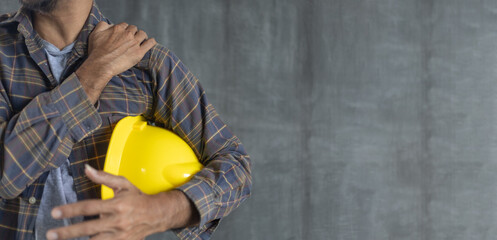 Construction worker shoulder pain on cement wall background with copy space