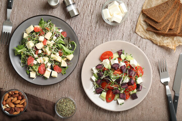 Delicious carrot salads served on wooden table, flat lay