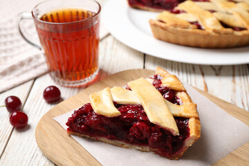 Slice of delicious fresh cherry pie on white wooden table, closeup