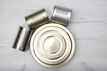 Various closed tin cans with food preserves on a light background. Canned food concept. Food donations. Copy space.
