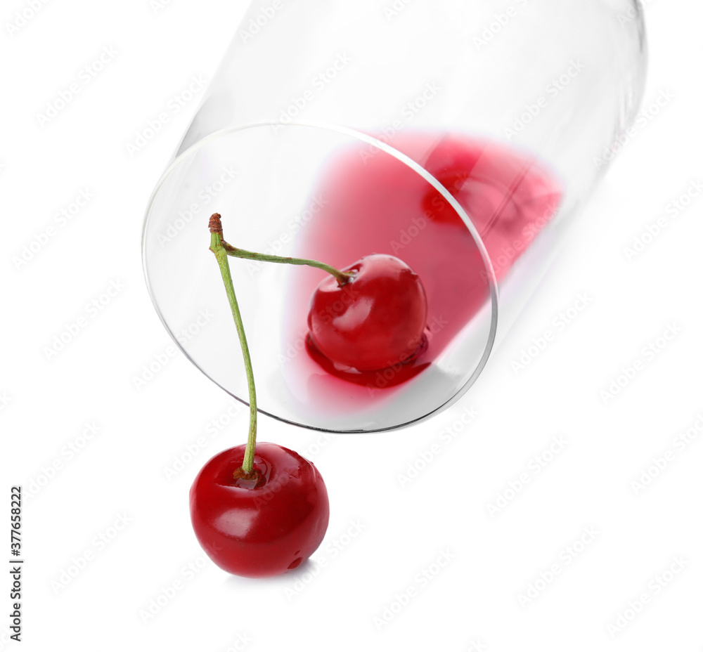 Wall mural Overturned glass of delicious cherry wine and ripe juicy berries isolated on white