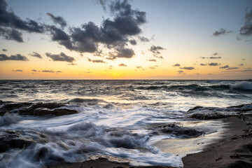 Fototapeta na wymiar Idyllic view of waves on sand at sunset