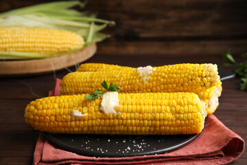 Fresh corn cobs with butter on table