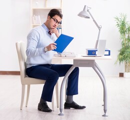 Young handsome businessman employee working in office at desk