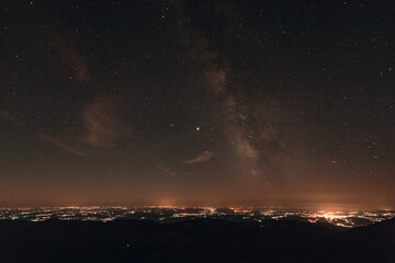 Obraz na płótnie Canvas Milky way galaxy and the city from the mountain